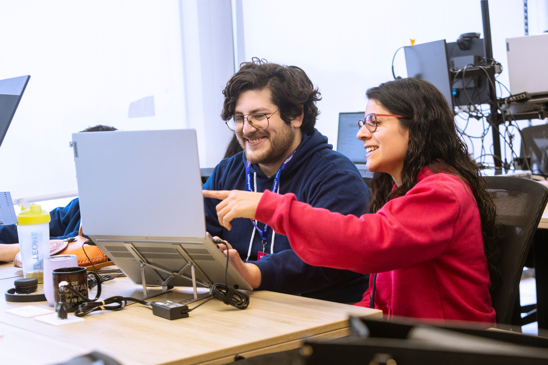 Bilingual Global teammates collaborating at a workstation
